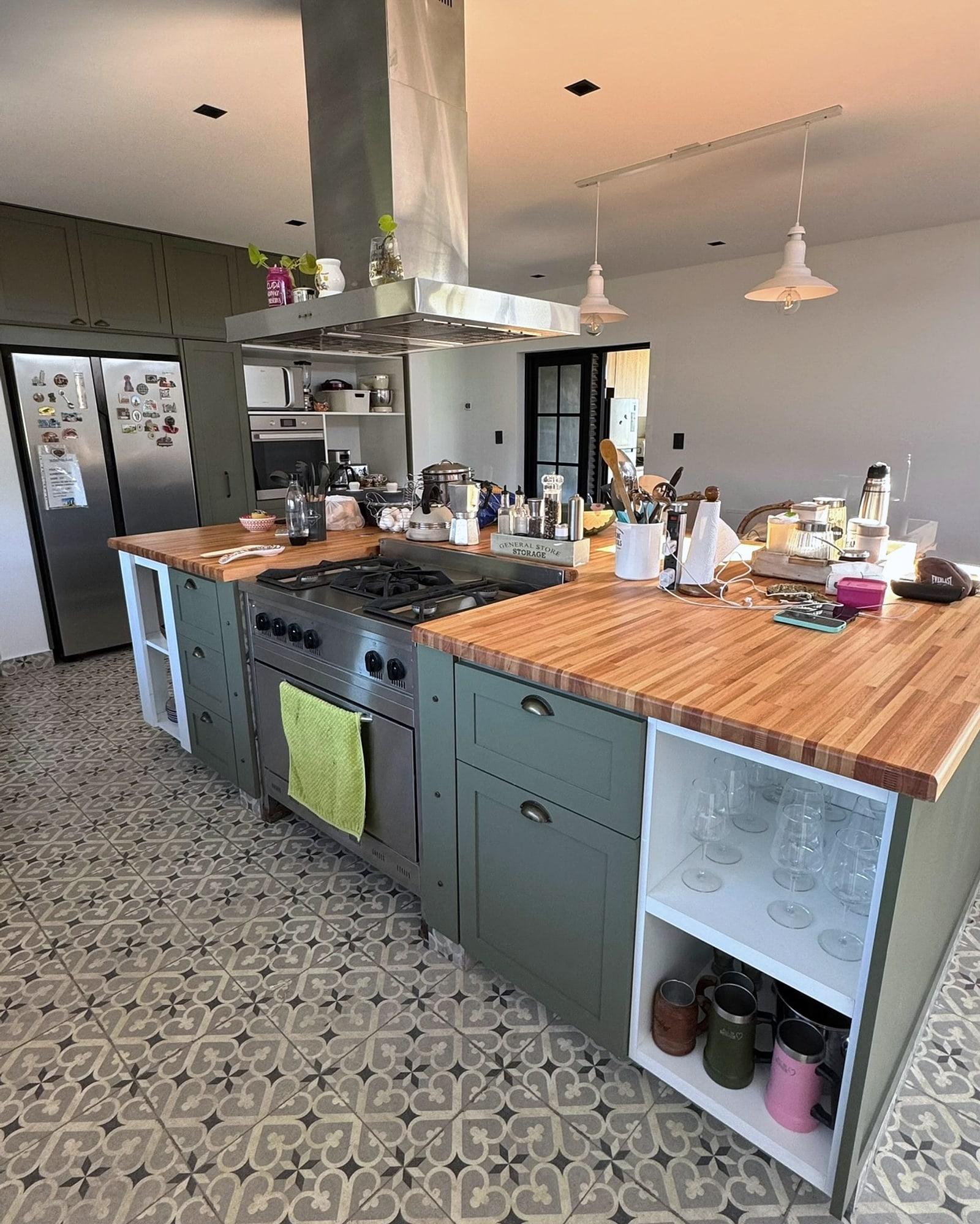 Cocina integral en verde con isla de madera