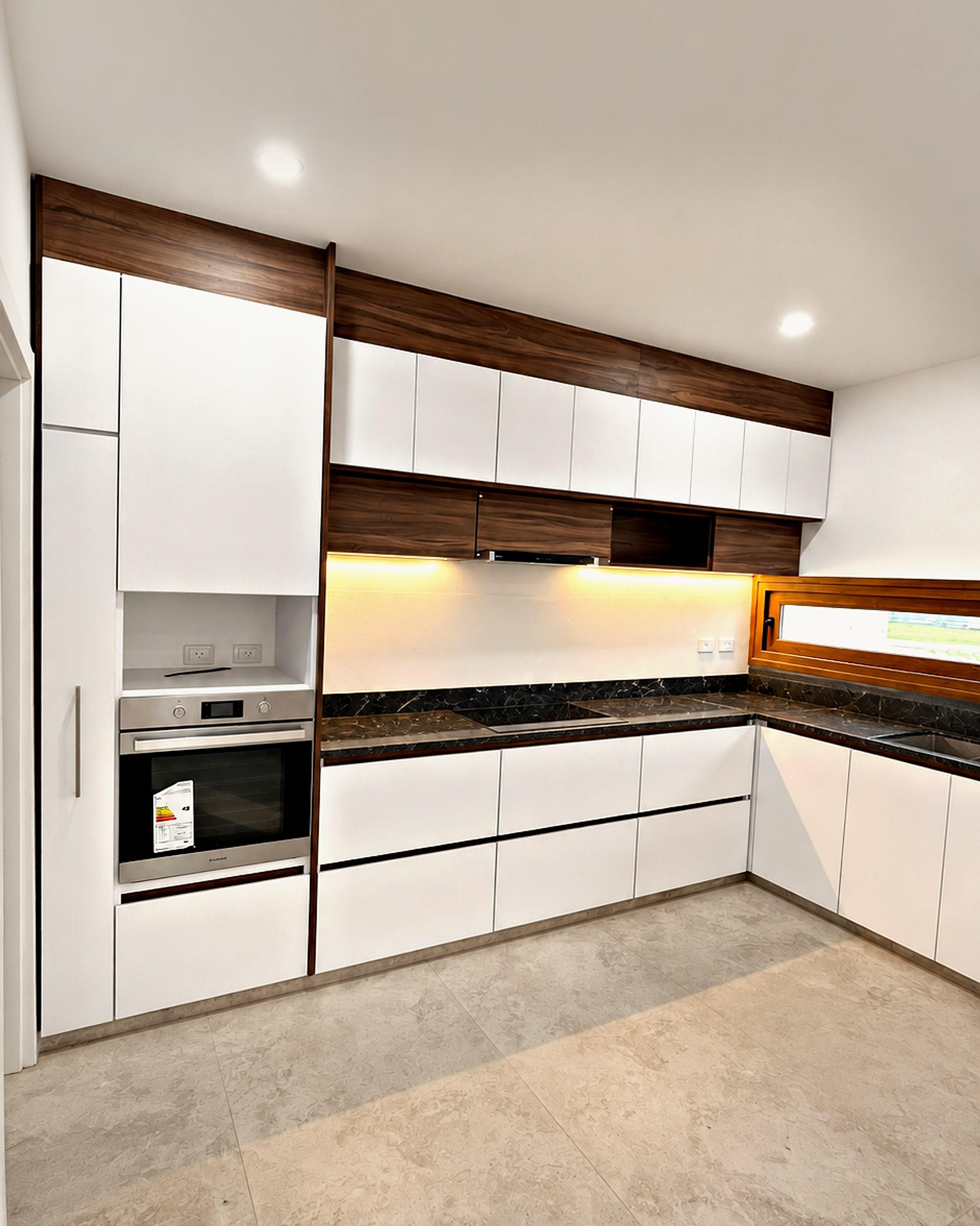 Cocina integral blanca con detalles en madera y mesada oscura
