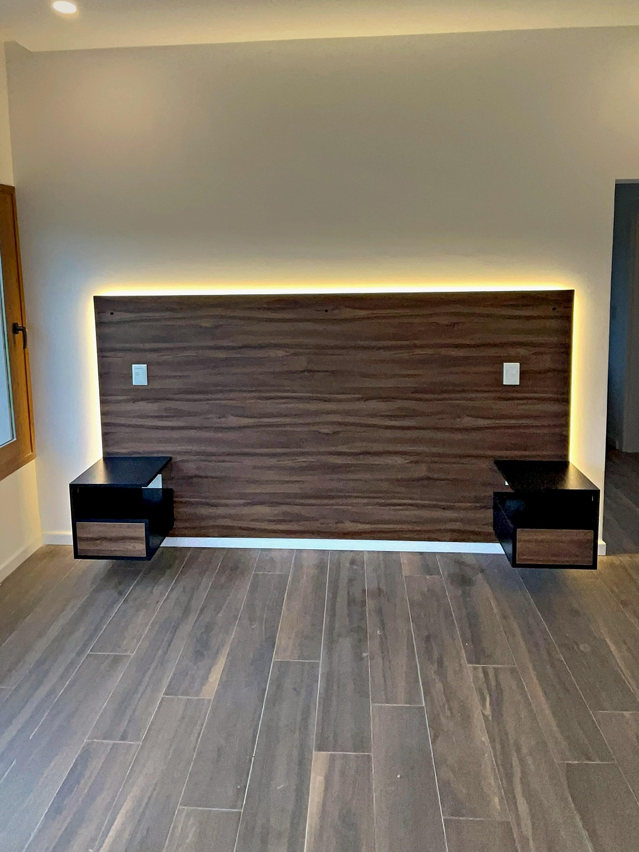 Respaldo de cama en madera con luz LED y mesas de luz flotantes